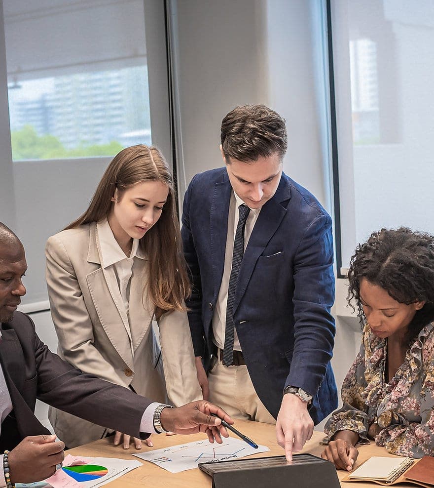 Colleagues gathered around a table reviewing a document together