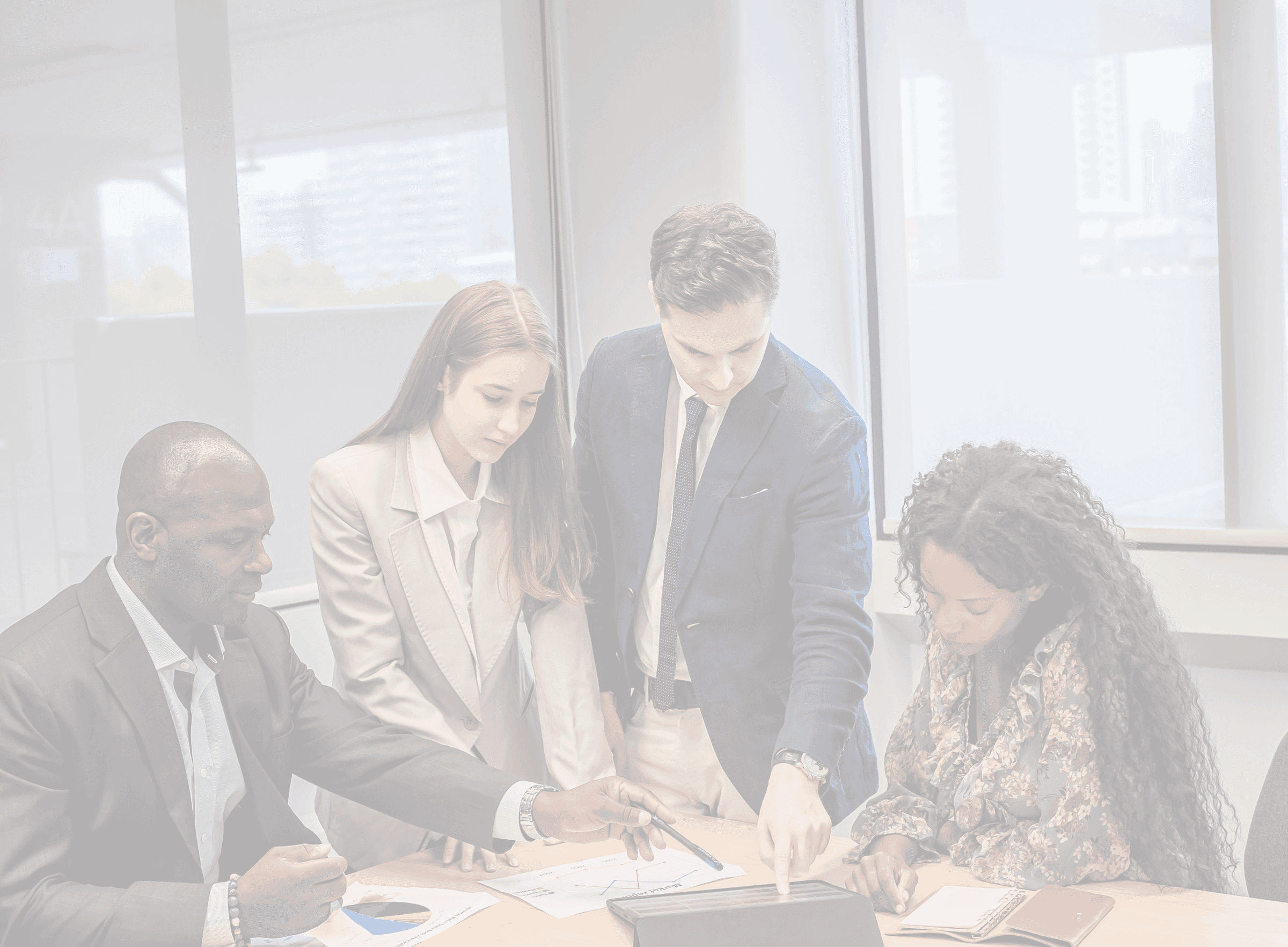 Colleagues gathered around a table reviewing a document together