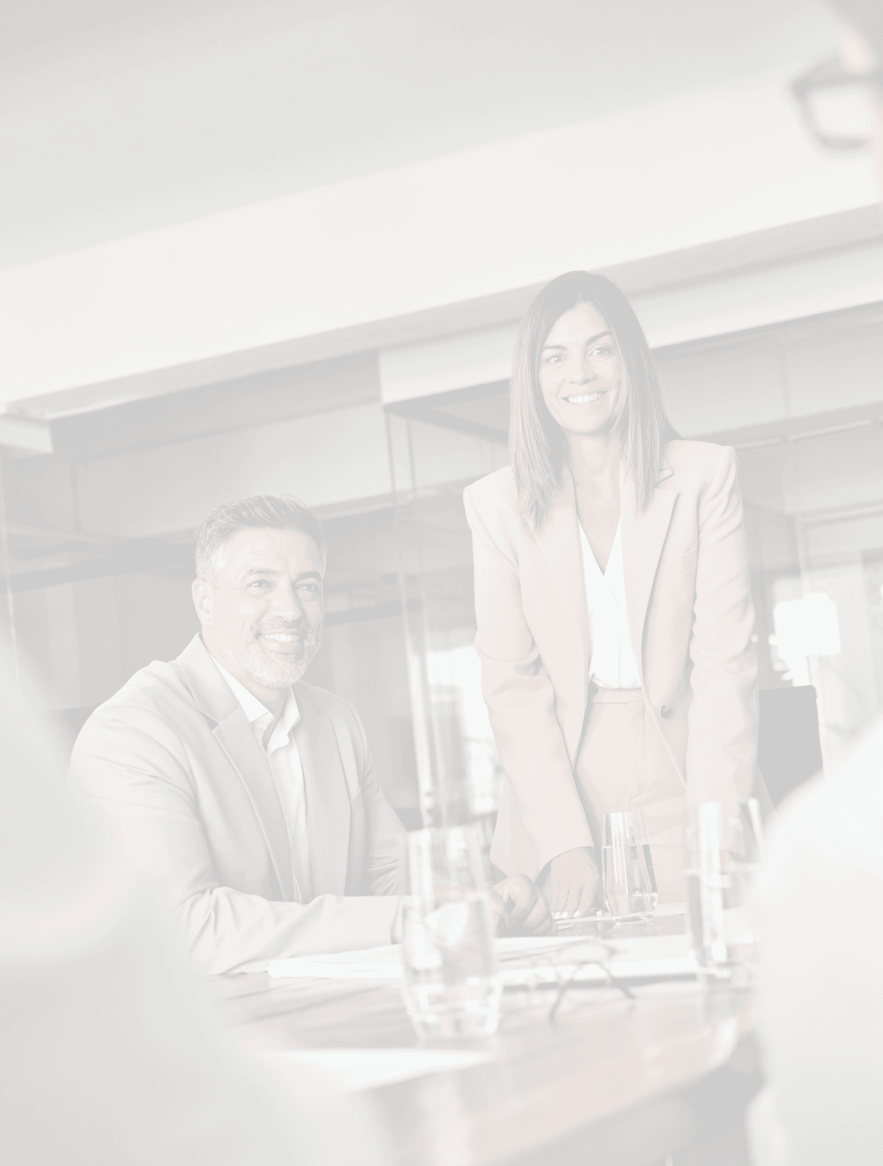 Two executives in a glass-walled meeting room during a discussion