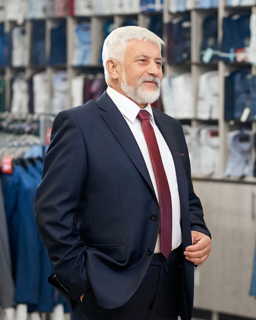 A senior retail leader on the shop floor of a menswear store
