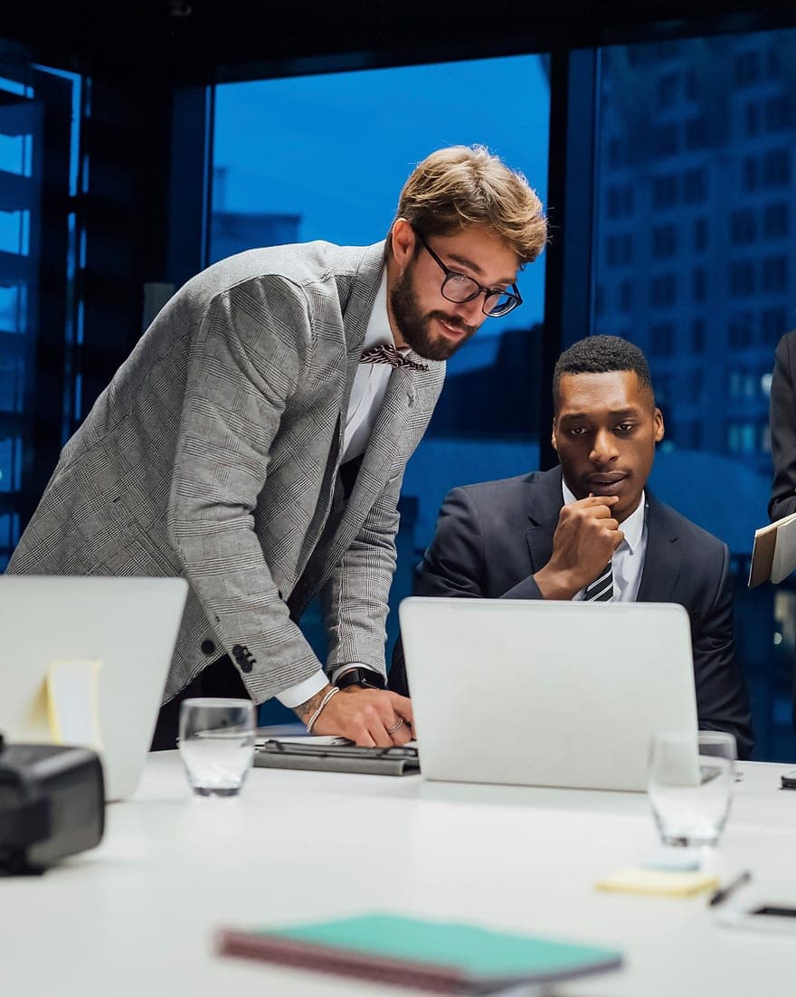 Business professionals collaborating around a laptop in a modern office