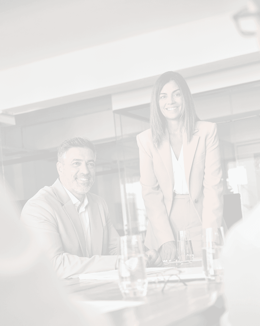 Smiling business woman and man at a boardroom table, Adastrum Consulting discussion