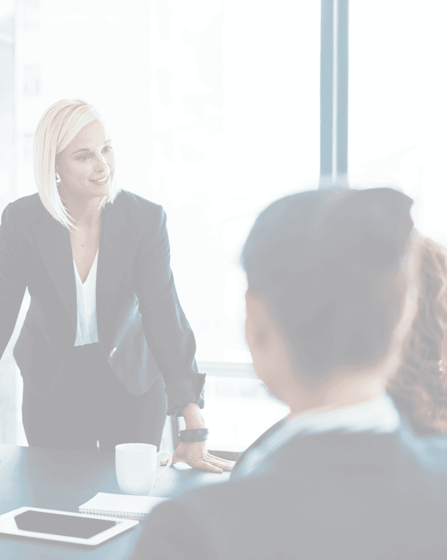 A leader in conversation with a colleague across a boardroom table