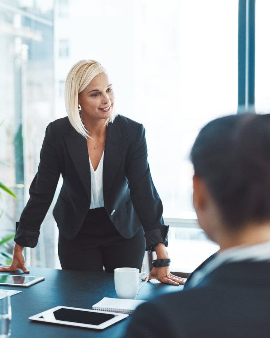 A leader in conversation with a colleague across a boardroom table