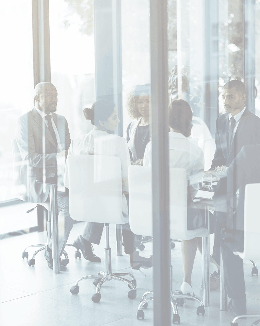 Business professionals gathered around a table in a glass-walled meeting room